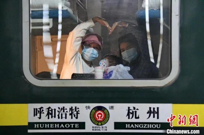 圖為登上轉(zhuǎn)運(yùn)火車的游客向額濟(jì)納比心?！⊥趵?攝