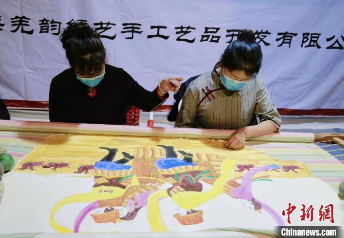 圖為皮繡藝人在市集上“秀”指尖技藝。　馬銘言 攝