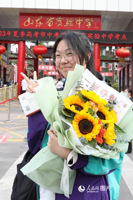 6月7日高考首日，山東67萬考生走進考場，拼搏逐夢。在山東省實驗中學考點，考生進考場前手捧向日葵花拍照留念，寓意“一舉奪魁”。人民網(wǎng)記者 劉祺攝