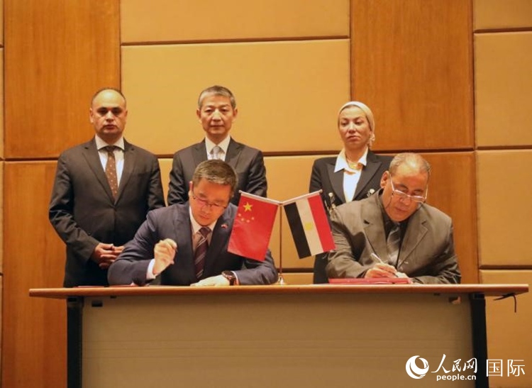 中國(guó)駐埃及使館公使張朝陽(yáng)與埃環(huán)境事務(wù)署工程和項(xiàng)目管理局局長(zhǎng)阿卜杜勒阿齊茲簽署交接證書(shū)。沈小曉攝