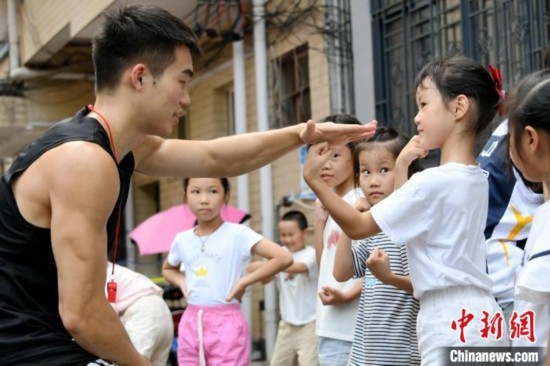 圖為大學(xué)生志愿者在組織孩子們參加體育健身活動(dòng)。廖光福 攝