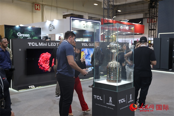 參觀者在TCL展臺前觀看南美解放者杯獎杯，據(jù)介紹，TCL是南美解放者杯（2023—2026賽季）全球官方合作伙伴。（人民網(wǎng)記者 時元皓攝）