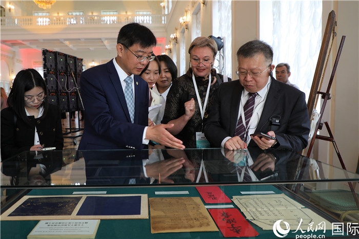 中俄圖書館論壇嘉賓共同參觀由俄羅斯國(guó)立列寧圖書館舉辦的館藏中國(guó)古籍善本圖書展。人民網(wǎng)記者 隋鑫攝）