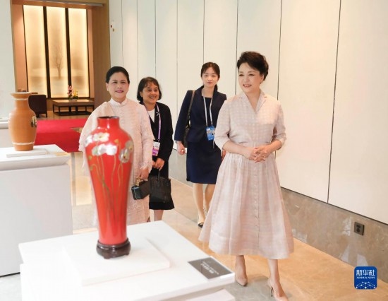 7月27日下午，國(guó)家主席習(xí)近平夫人彭麗媛在四川成都會(huì)見陪同印度尼西亞總統(tǒng)佐科來華出席第31屆世界大學(xué)生夏季運(yùn)動(dòng)會(huì)開幕式并訪華的總統(tǒng)夫人伊莉亞娜。這是彭麗媛和伊莉亞娜欣賞成都特色非遺工藝品。新華社記者 丁林 攝