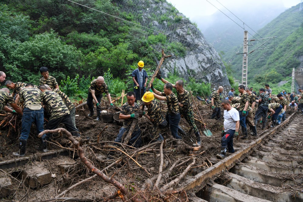8月1日，在北京市門頭溝區(qū)水峪嘴村附近一段被阻斷的鐵路線上，中鐵六局工作人員在清理軌道上的雜物，全力恢復(fù)交通。新華社記者 鞠煥宗 攝