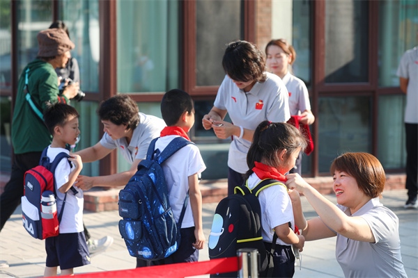 8月30日，雄安史家胡同小學學生體驗學校生活。老師為學生佩戴?；?。