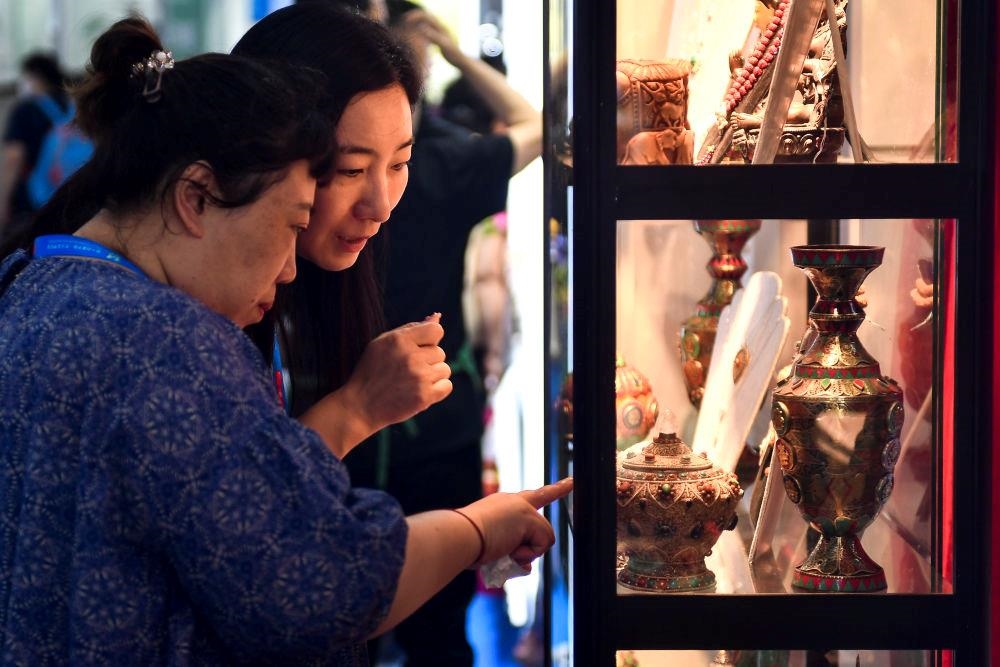 △2023年8月24日，參觀者在第十四屆中國—東北亞博覽會現(xiàn)場選購尼泊爾特色商品。