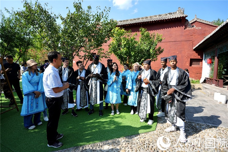 圖為選手們聽導游講解。人民網 盧鵬宇攝