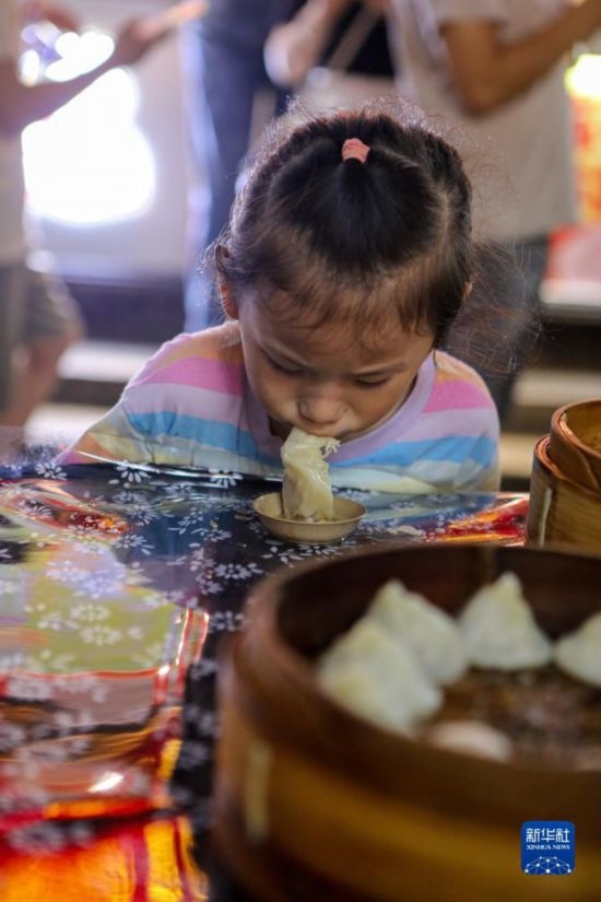 9月27日，小朋友在南翔小籠長街宴上品嘗南翔小籠。