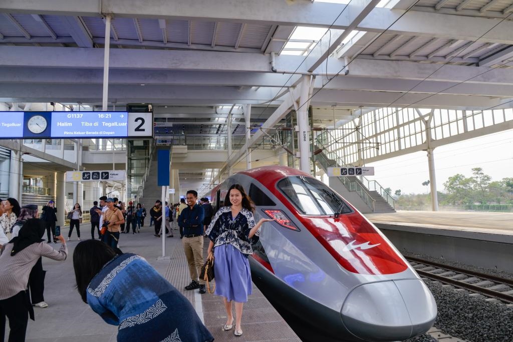 10月17日，在印度尼西亞萬隆德卡魯爾站，乘客在站臺上和雅萬高鐵高速動車組列車合影。