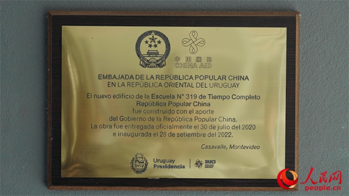 小學墻上懸掛的中國援助標識。人民網(wǎng)記者 張若涵攝