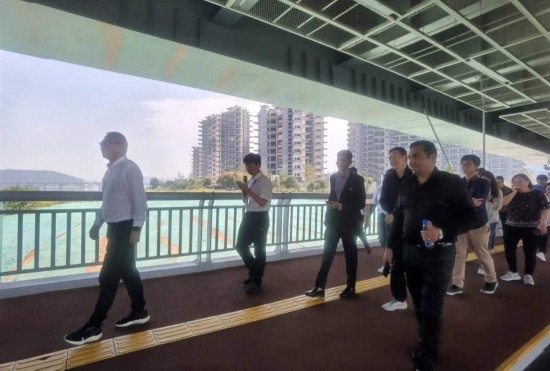 10月24日，2023“一帶一路”媒體合作論壇聯(lián)合采訪團(tuán)團(tuán)員走在清水塘大橋景觀通道上。本報(bào)記者 常雯宜攝