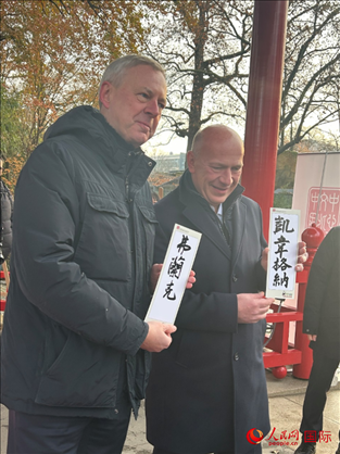 柏林市長(zhǎng)韋格納（右）、動(dòng)物園監(jiān)事會(huì)主席布魯克曼（左）手持中國(guó)文化中心工作人員現(xiàn)場(chǎng)手書的中文名字。人民網(wǎng)記者 徐馨攝