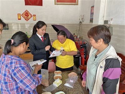  圖⑤：龍圩區(qū)法院法官到群眾家中開展法治宣傳。資料圖片