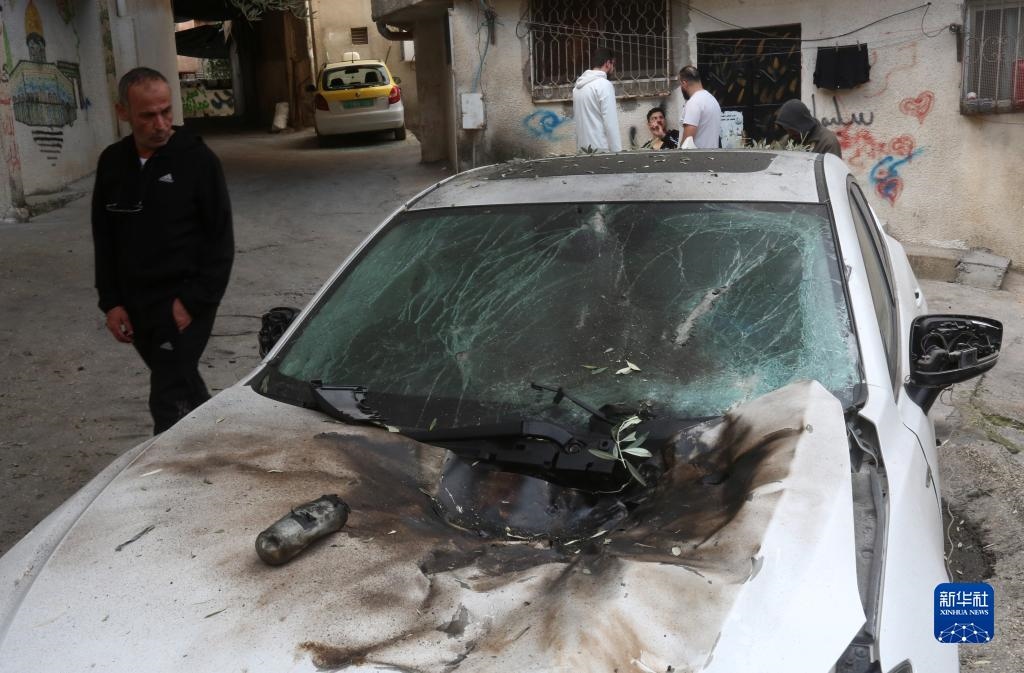 12月17日，在約旦河西岸城市圖勒凱爾姆附近的一處難民營，人們查看在沖突中損毀的車輛。新華社發(fā)（尼達爾·艾仕塔耶攝）