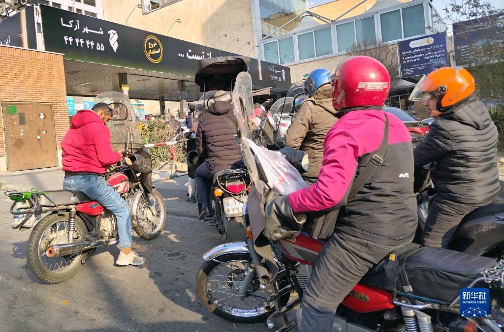 12月18日，摩托車在伊朗首都德黑蘭的一家加油站外等待加油。新華社記者 沙達(dá)提 攝