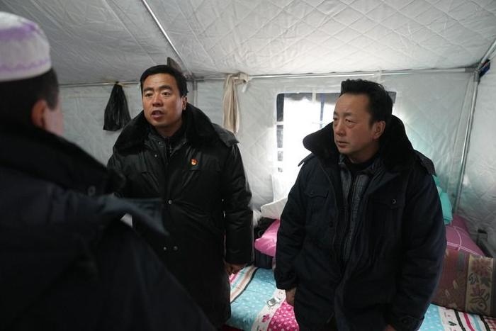 2023年12月22日，積石山縣大河家鎮(zhèn)大河村黨支部書記馬成忠（右二）在帳篷里和受災群眾交流。新華社記者 陳斌 攝