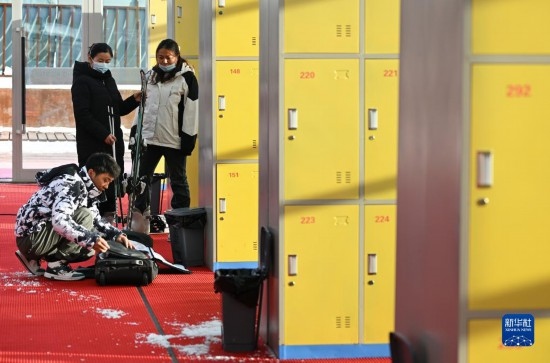 12月21日，游客在滑雪服務(wù)大廳整理滑雪裝備。