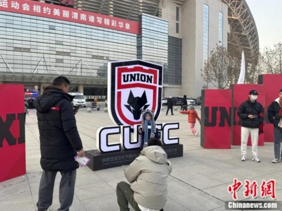 球迷們與隊(duì)徽合影。記者 卞立群 攝