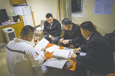 圖②：法官向船長講解相關法律規(guī)定，查看船舶資料，并與船方辦理扣押船舶的手續(xù)。