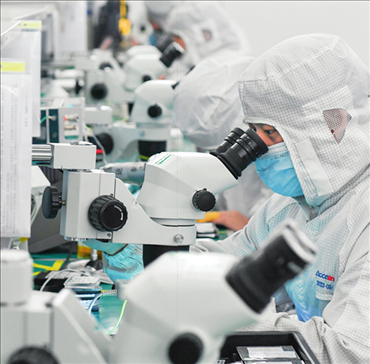 在位于武漢中國光谷的光電器件研發(fā)制造商——武漢光迅科技股份有限公司生產(chǎn)車間內(nèi)，技術(shù)人員在光模塊生產(chǎn)線作業(yè)（2023年4月11日攝）。程敏攝/本刊