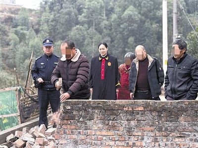  圖③：庭審結(jié)束后，在法官的見證下，陳某在院壩邊重新開鑿一條通道。