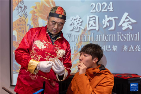 1月28日，在上海豫園舉行的民俗活動上，美國馬斯卡廷中學(xué)學(xué)生在非遺傳承人的指導(dǎo)下吹糖偶。 新華社記者 王翔 攝