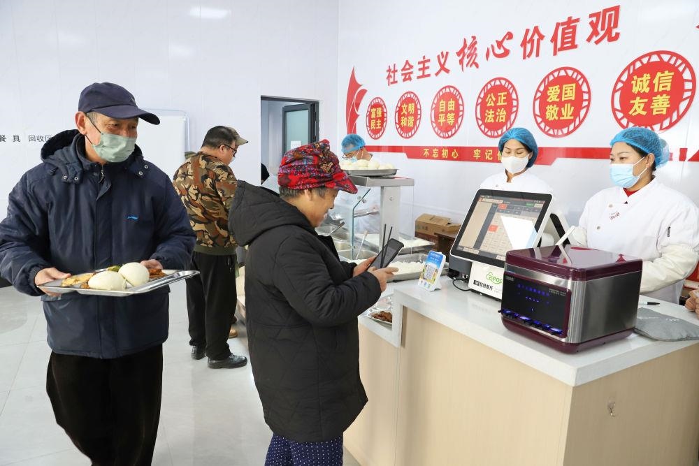 △2024年2月1日，市民在河北涿州市雙塔街道永濟秀園小區(qū)便民食堂內購買午餐。