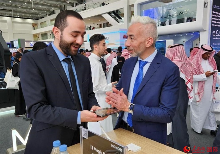 兩名觀眾在榮耀手機(jī)展臺(tái)前交流。人民網(wǎng)記者 管克江攝