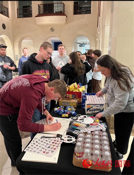 學生們出發(fā)前紛紛在留言簿留言。人民網(wǎng)記者 鄧圩攝