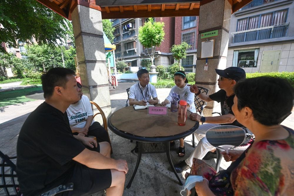 △2023年7月21日，在位于浙江杭州臨安區(qū)錦南街道水岸陽光小區(qū)的陽光議事廳，街道干部在聽取居民們反映的問題及意見。