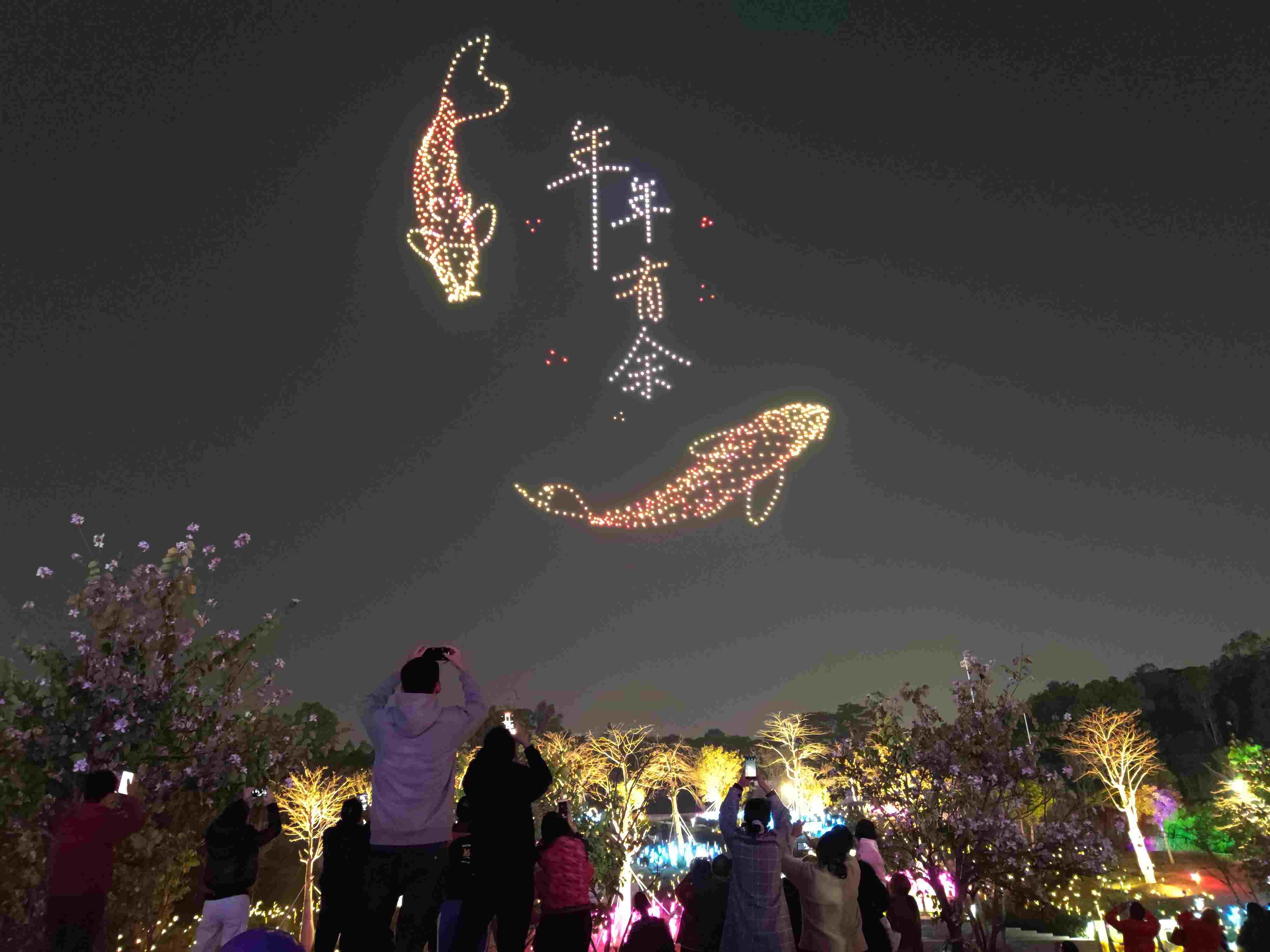 △ 2024年2月10日，深圳北站中心公園，春節(jié)主題無人機(jī)燈光秀引來眾多游客駐足觀看。
