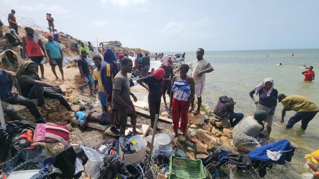 2023年7月26日，在突尼斯與利比亞邊境的艾季迪爾角，眾多移民滯留在地中海海岸邊。新華社發(fā)（哈姆扎·圖爾基亞攝）