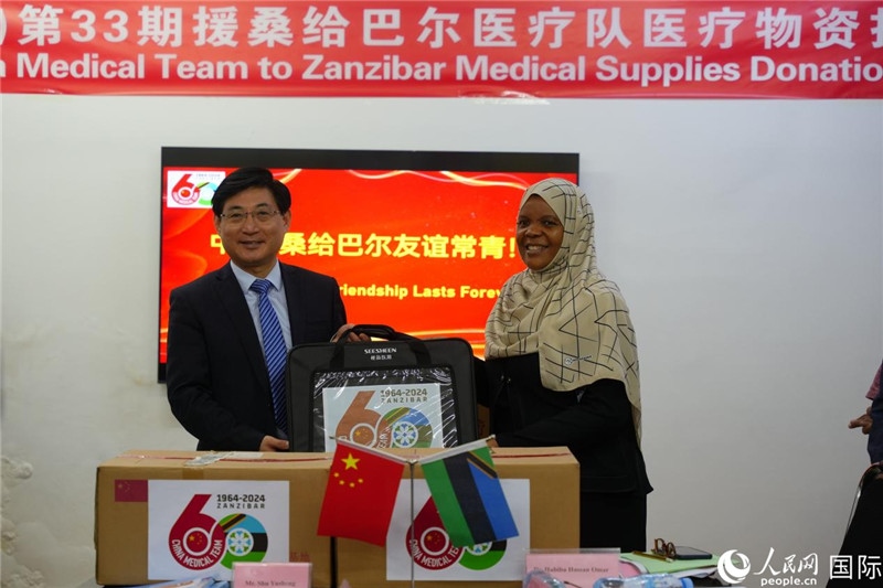 江蘇省蘇北人民醫(yī)院黨委書記束余聲捐贈物資與桑衛(wèi)生部首席秘書哈比巴。中國援桑醫(yī)療隊供圖