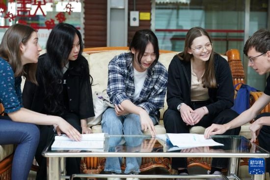 4月28日，宋智孝（右二）和胡靈月（左一）在北京首都師范大學(xué)校園內(nèi)與同學(xué)交流。新華社記者 彭子洋 攝