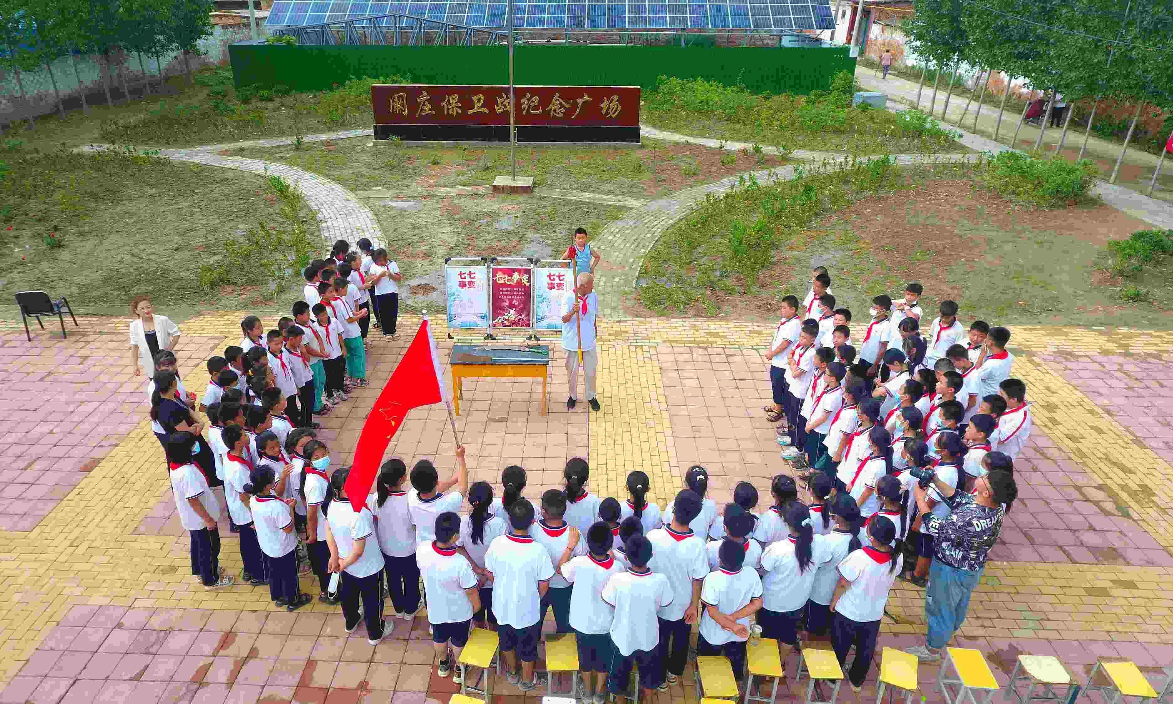 2022年7月6日，山東省聊城市，在茌平區(qū)菜屯鎮(zhèn)闞莊村的闞莊保衛(wèi)戰(zhàn)紀(jì)念廣場(chǎng)，闞莊保衛(wèi)戰(zhàn)親歷者王光木老人為小學(xué)生們講述抗戰(zhàn)故事，展示大刀、長(zhǎng)矛。