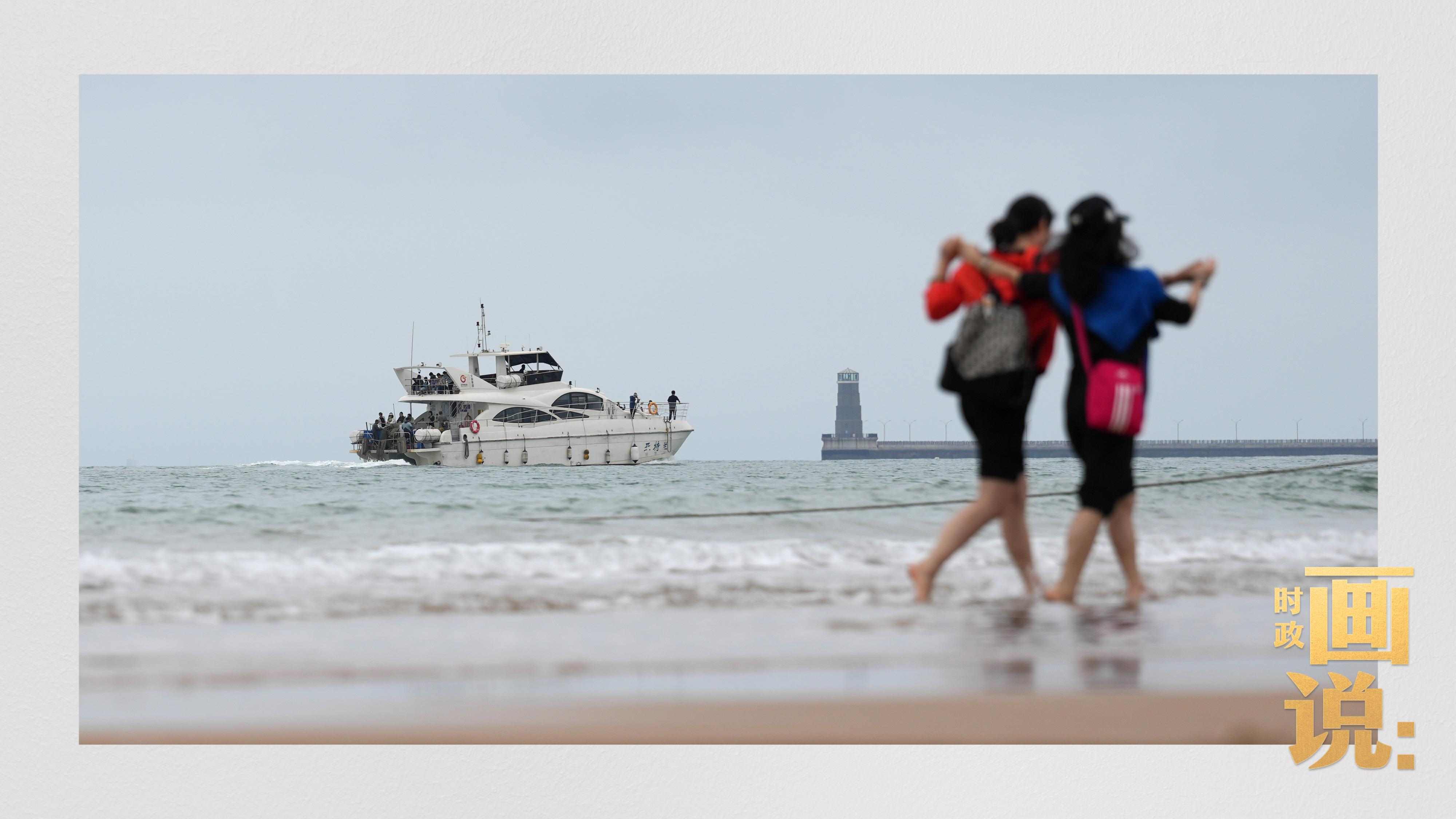 △日照陽光海岸綠道上的萬平口景區(qū)，一對游客在海浪中翩然起舞。