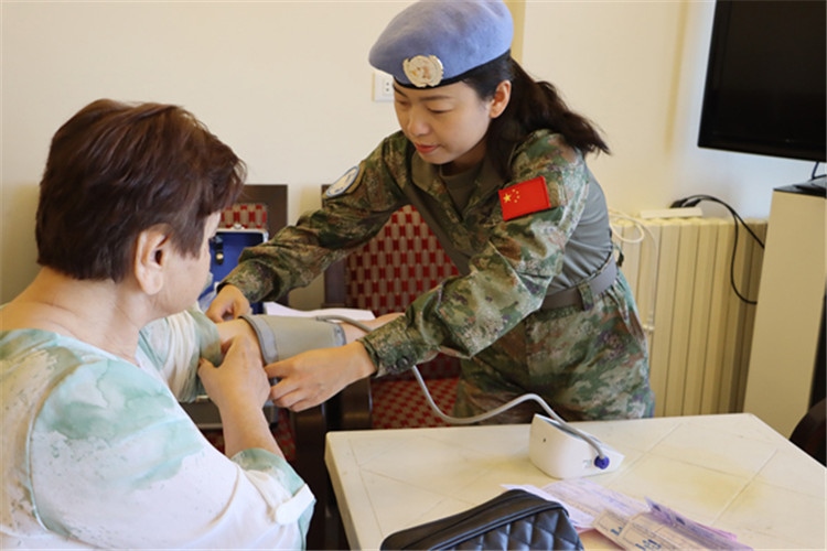 【1】 醫(yī)療分隊隊員為當?shù)鼗颊邷y量血壓。曾德樂攝