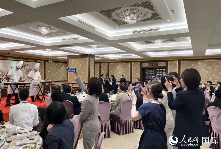 國家級非物質(zhì)文化遺產(chǎn)、全聚德片鴨工藝吸引代表團(tuán)成員拍照留念。