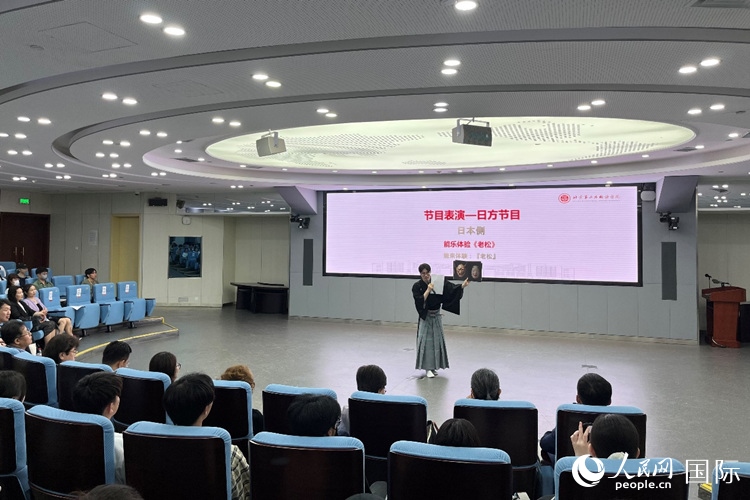 日本大學(xué)生介紹能樂知識(shí)。人民網(wǎng)記者 陳思攝