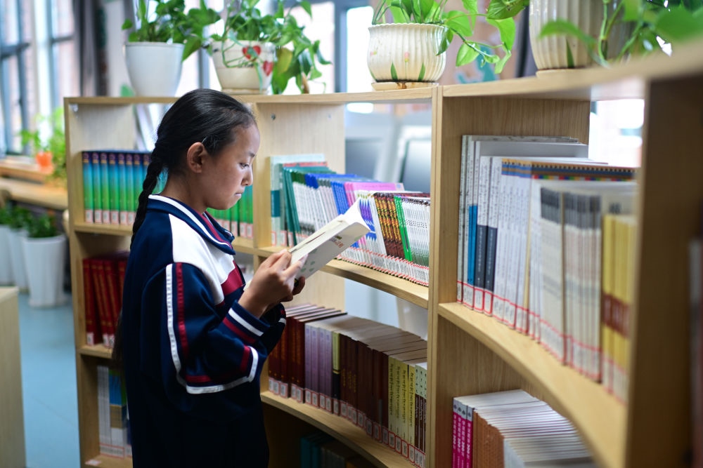 6月18日，果洛西寧民族中學(xué)學(xué)生尼東拉毛在圖書室看書。