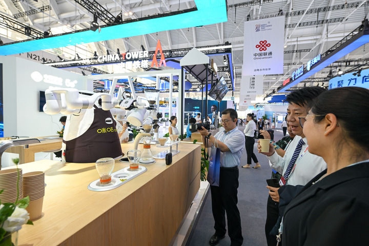 6月20日，與會者品嘗機(jī)器人沖調(diào)出的咖啡。新華社記者 孫凡越 攝