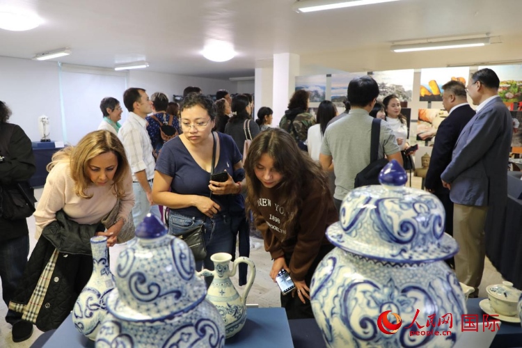 在展覽現(xiàn)場，觀眾們駐足欣賞德化瓷和墨西哥彩瓷。人民網(wǎng) 埃內(nèi)斯托·多明戈斯攝
