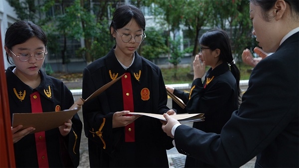 圖①：武平法院干警向?qū)W生分發(fā)道具卷宗。