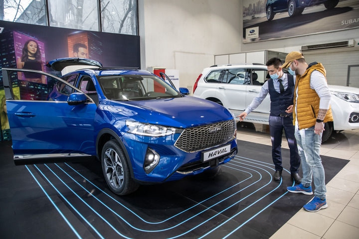 2021年4月1日，銷售人員在哈薩克斯坦阿拉木圖市經(jīng)銷商店向消費(fèi)者介紹哈弗汽車。新華社發(fā)（阿斯塔納汽車公司供圖）