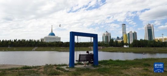 6月30日，一名女子在哈薩克斯坦首都阿斯塔納伊希姆河畔休息。新華社記者 王建華 攝