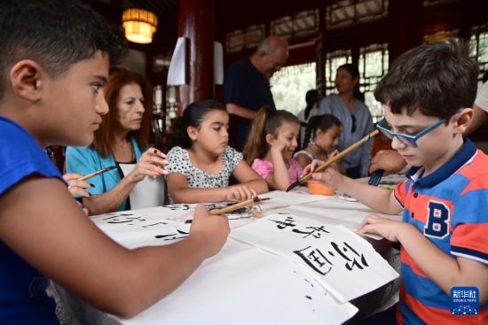 7月4日，在馬耳他桑塔露琪亞市的中國古典園林“靜園”，人們體驗中國書法。新華社發(fā)（喬納森·博格 攝）