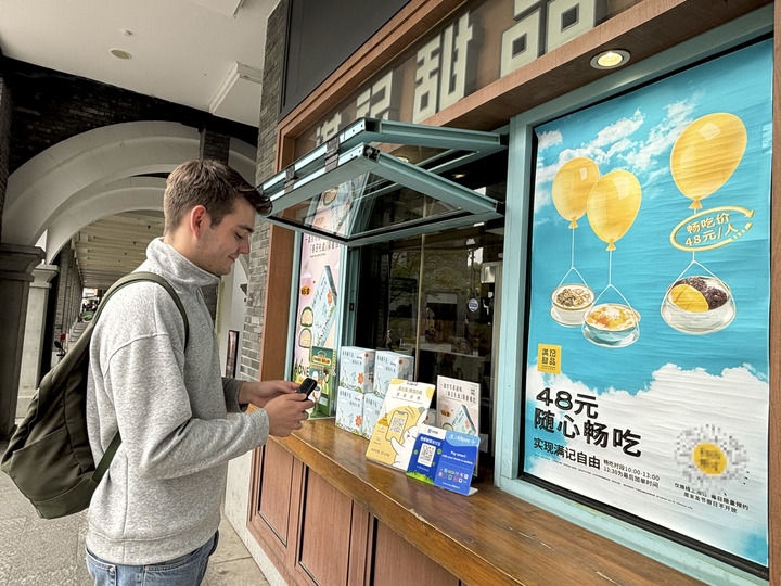 來(lái)自德國(guó)的留學(xué)生理查德在杭州西湖邊一家商鋪使用支付寶掃碼支付（2024年4月11日攝）。新華社發(fā)