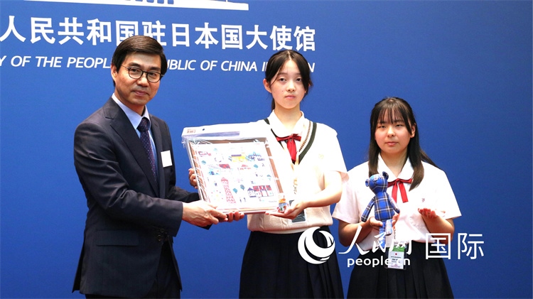 日本小大使向中國駐日本大使館臨時代辦施泳贈送當(dāng)?shù)靥厣Y品。人民網(wǎng) 許可攝