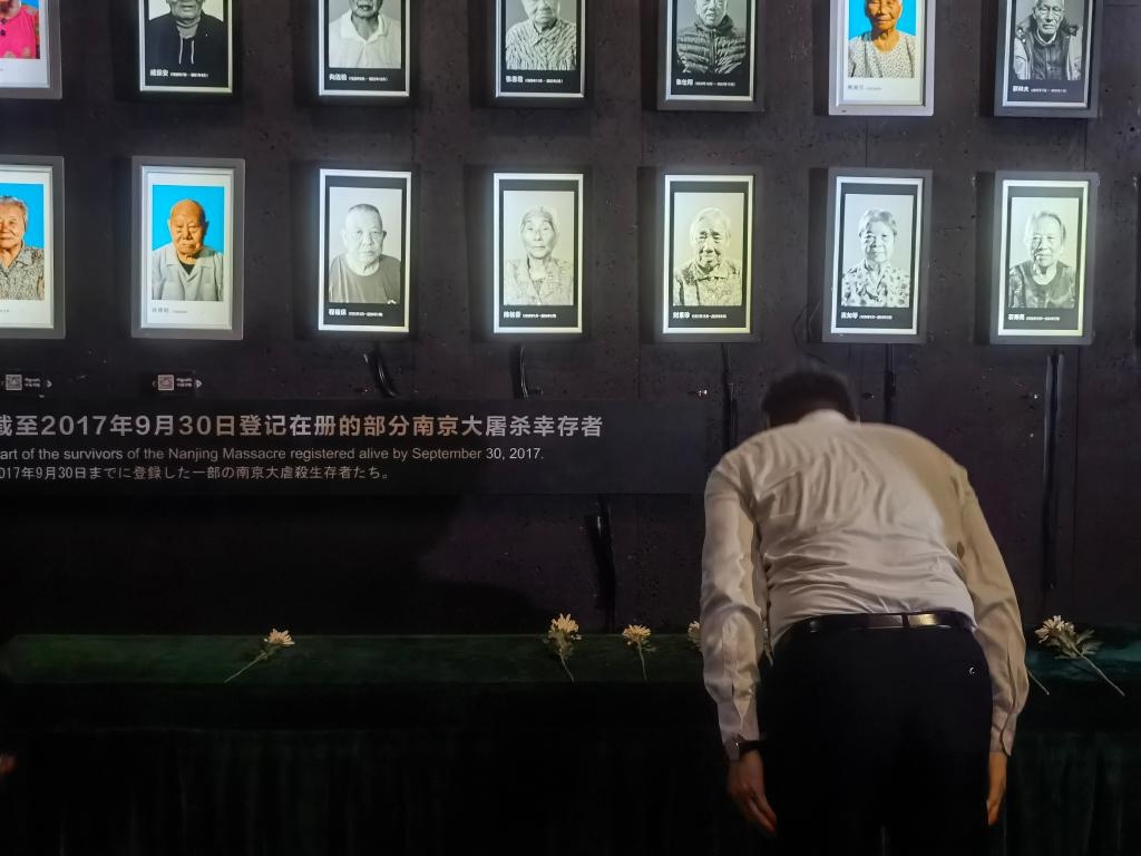 7月18日，人們向離世的南京大屠殺幸存者獻花、鞠躬。新華社記者邱冰清 攝